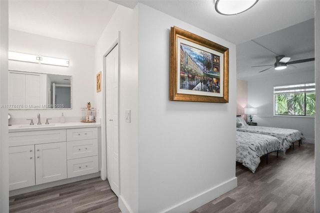 bathroom featuring baseboards, wood finished floors, ensuite bath, and a ceiling fan
