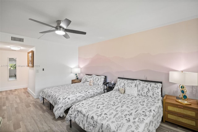 bedroom featuring wood finished floors, baseboards, ceiling fan, and visible vents