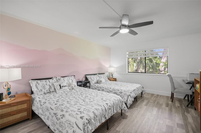 bedroom featuring baseboards, wood finished floors, and a ceiling fan