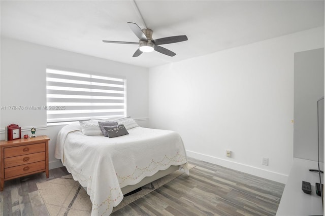 bedroom featuring baseboards, wood finished floors, and a ceiling fan