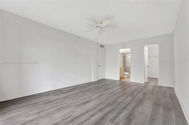 spare room featuring visible vents, a ceiling fan, and light wood finished floors