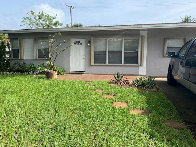 single story home featuring stucco siding and a front lawn