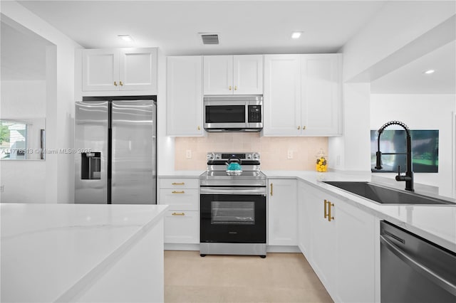 kitchen with visible vents, a sink, white cabinetry, stainless steel appliances, and decorative backsplash