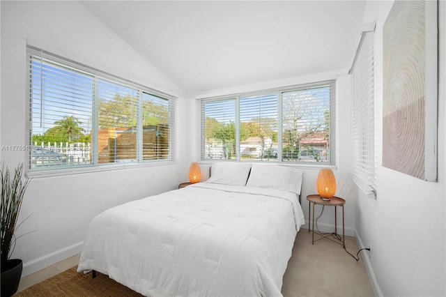 bedroom with baseboards and lofted ceiling
