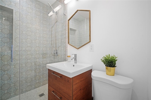 bathroom with toilet, a stall shower, and vanity