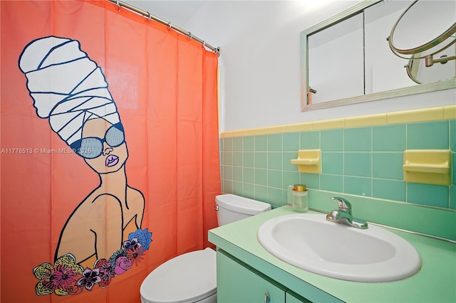 bathroom with vanity, a shower with curtain, a wainscoted wall, toilet, and tile walls