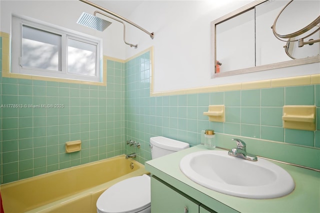 full bath with toilet, vanity, shower / washtub combination, and tile walls