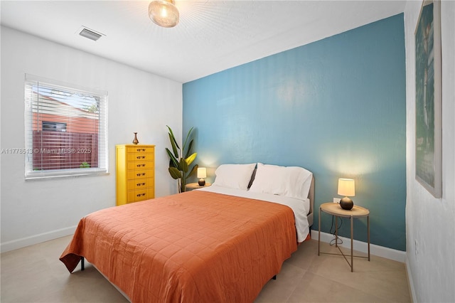 bedroom with baseboards and visible vents