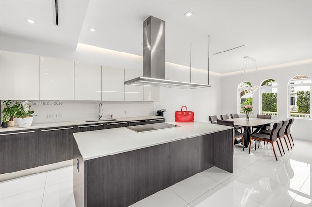 3106 NE 210th Ter, Aventura, FL 33180 - kitchen with modern cabinets, a sink, cooktop, island exhaust hood, and light countertops