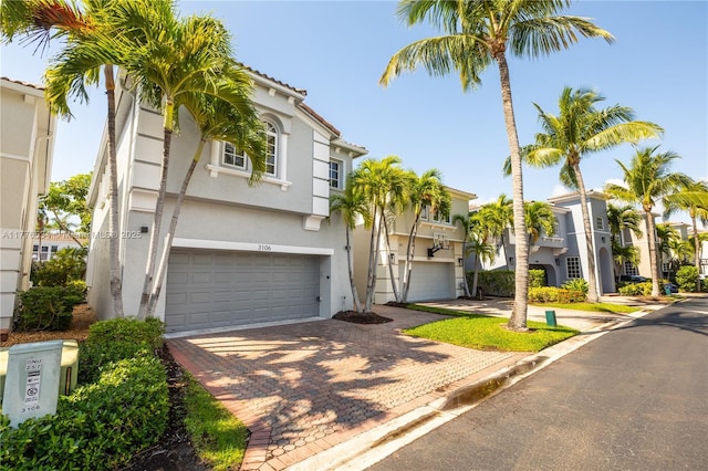 3106 NE 210th Ter, Aventura, FL 33180 - view of front facade with stucco siding, a garage, and decorative driveway