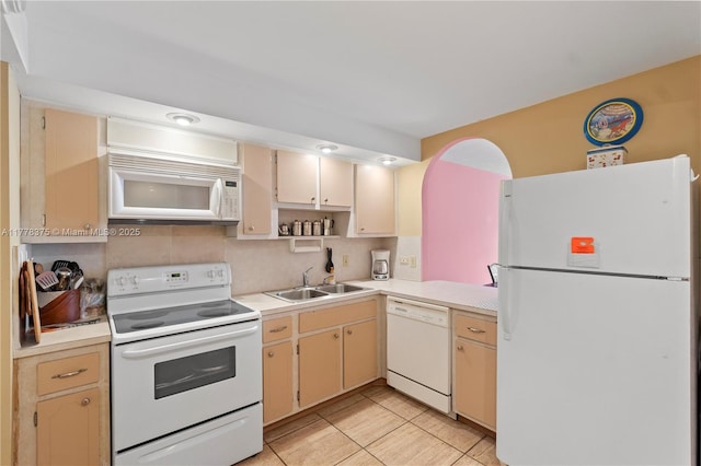 kitchen featuring white appliances, open shelves, cream cabinetry, light countertops, and a sink