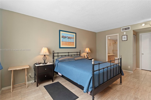 bedroom with visible vents, baseboards, ensuite bath, and a textured ceiling