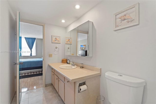 ensuite bathroom featuring toilet, recessed lighting, ensuite bath, vanity, and tile patterned floors
