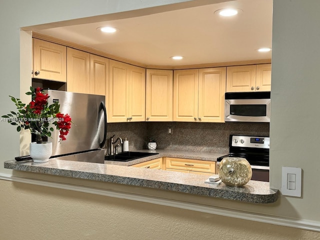 kitchen with appliances with stainless steel finishes, decorative backsplash, a sink, and recessed lighting
