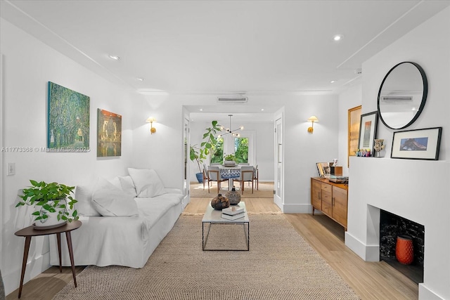 living area featuring visible vents, baseboards, an inviting chandelier, light wood-type flooring, and recessed lighting