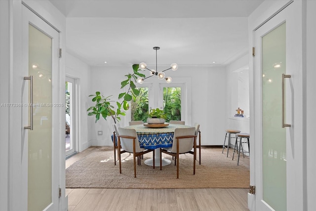 dining area featuring baseboards, a chandelier, and light wood-style floors