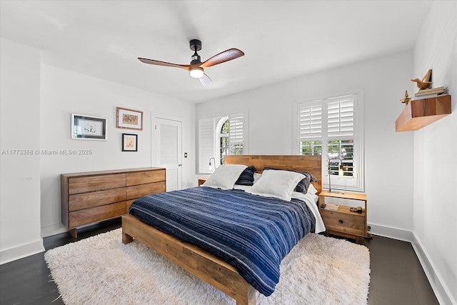 bedroom featuring dark wood-type flooring, baseboards, and ceiling fan