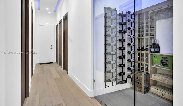 wine area featuring baseboards, light wood-type flooring, and recessed lighting