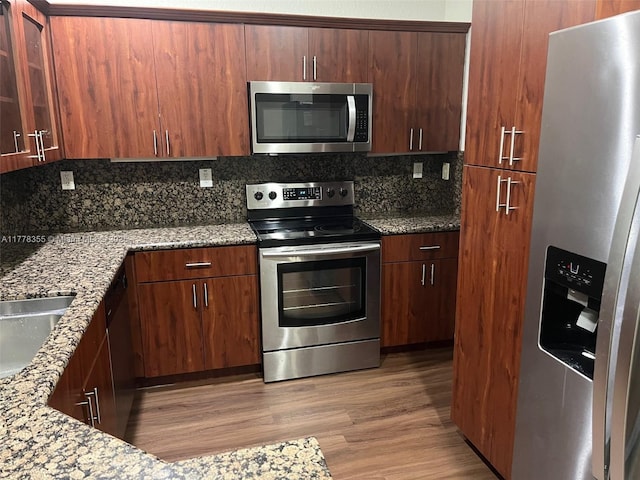 977 SW 153rd Path, Miami, FL 33194 - kitchen with appliances with stainless steel finishes, backsplash, light wood-style flooring, stone countertops, and glass insert cabinets