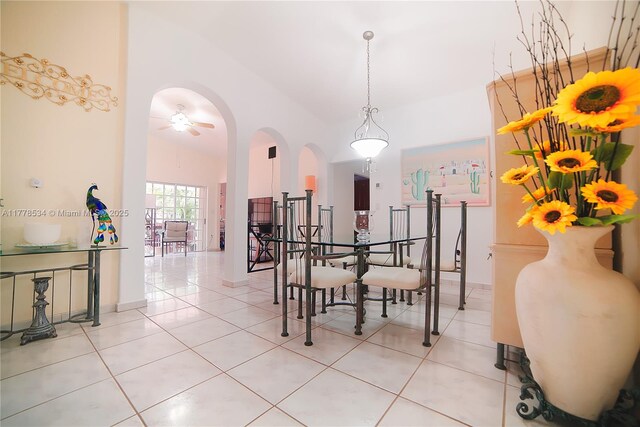 14426 NW 88th Ave, Miami Lakes, FL 33018 - dining area with light tile patterned floors, arched walkways, ceiling fan, a high ceiling, and baseboards
