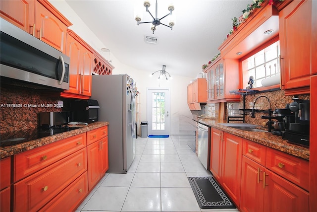 14426 NW 88th Ave, Miami Lakes, FL 33018 - kitchen featuring appliances with stainless steel finishes, a sink, a chandelier, backsplash, and glass insert cabinets
