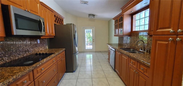 14426 NW 88th Ave, Miami Lakes, FL 33018 - kitchen with appliances with stainless steel finishes, a sink, light tile patterned flooring, decorative backsplash, and brown cabinetry