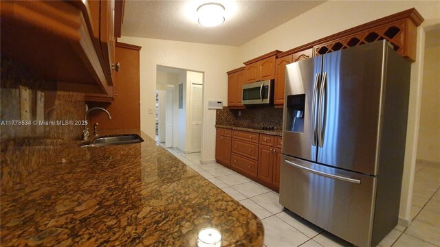14426 NW 88th Ave, Miami Lakes, FL 33018 - kitchen with appliances with stainless steel finishes, a sink, backsplash, light tile patterned floors, and dark stone counters