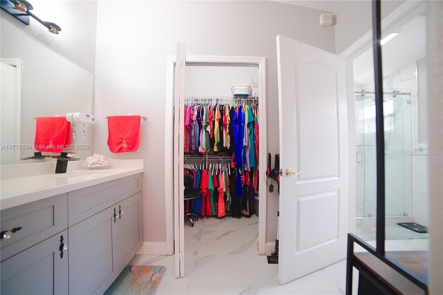 14426 NW 88th Ave, Miami Lakes, FL 33018 - full bath with marble look tiles, vanity, a walk in closet, baseboards, and an enclosed shower