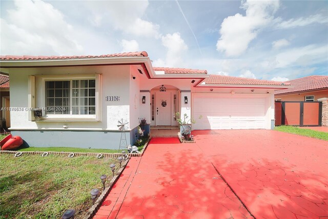 14426 NW 88th Ave, Miami Lakes, FL 33018 - view of front of house featuring stucco siding, a tiled roof, an attached garage, and driveway