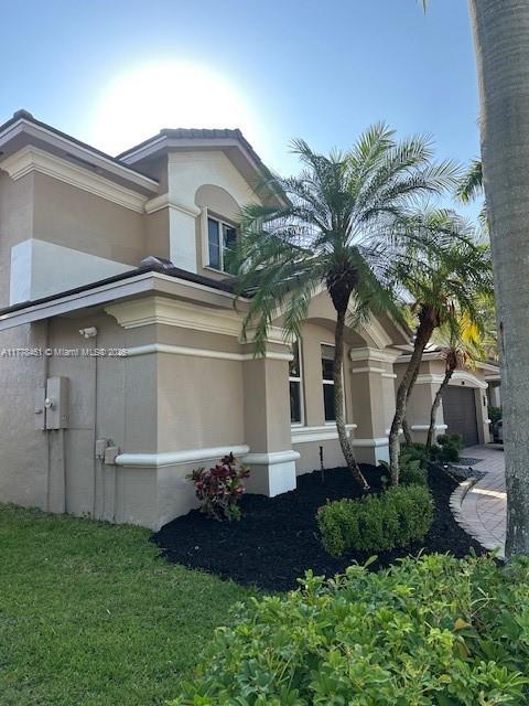 2269 Quail Roost Dr, Weston, FL 33327 - view of side of home with stucco siding and a garage