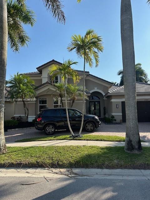 2269 Quail Roost Dr, Weston, FL 33327 - view of front of property with decorative driveway, stucco siding, and a tiled roof
