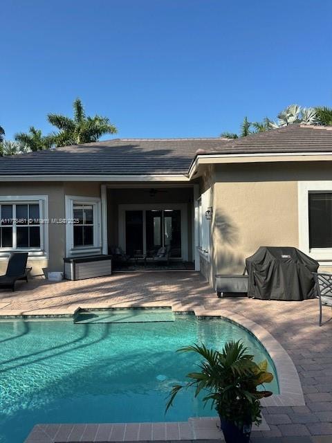 2269 Quail Roost Dr, Weston, FL 33327 - rear view of property with a patio area and an outdoor pool