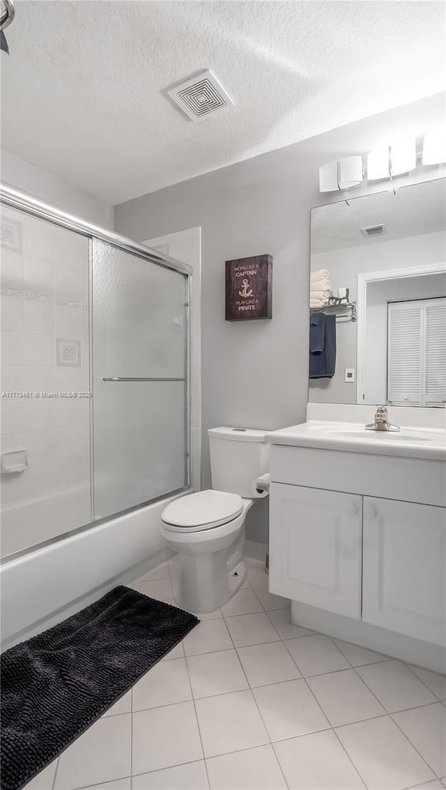 2269 Quail Roost Dr, Weston, FL 33327 - full bathroom with toilet, vanity, a textured ceiling, bath / shower combo with glass door, and tile patterned flooring