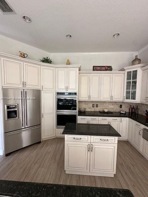 2269 Quail Roost Dr, Weston, FL 33327 - kitchen featuring stainless steel appliances, light wood-style floors, crown molding, dark countertops, and a kitchen island