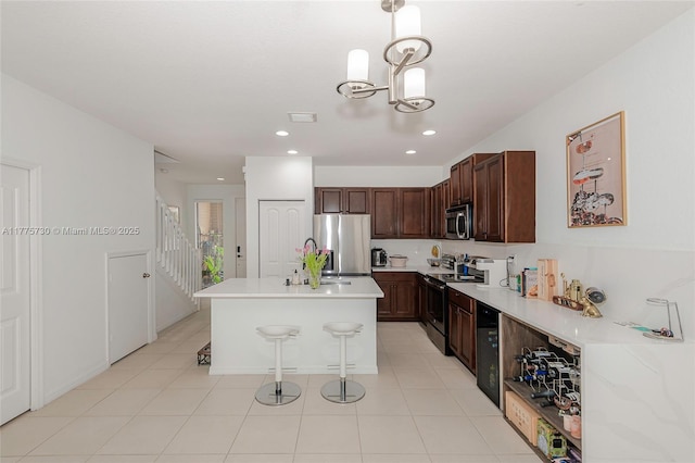 1091 NW 33rd Ct, Pompano Beach, FL 33064 - kitchen with a sink, light countertops, a breakfast bar, a kitchen island with sink, and stainless steel appliances