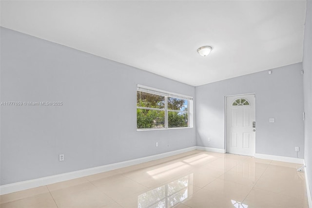 unfurnished room with tile patterned floors and baseboards