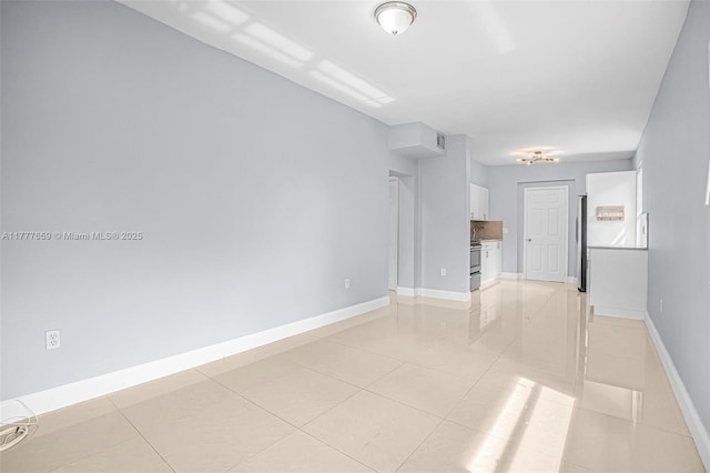 empty room with light tile patterned flooring, baseboards, and visible vents