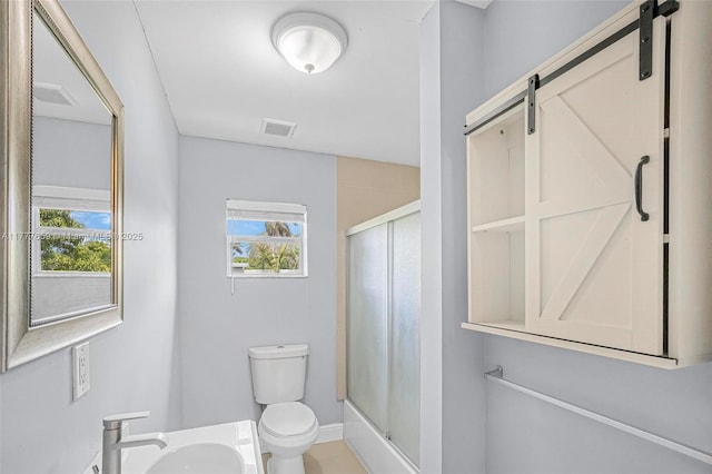 full bath featuring a sink, visible vents, toilet, and a shower stall