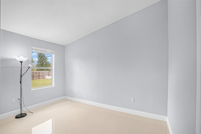 unfurnished room with baseboards and light tile patterned flooring