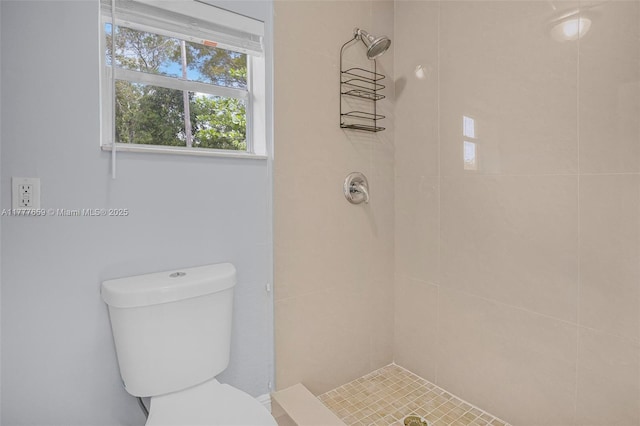 bathroom featuring a tile shower and toilet