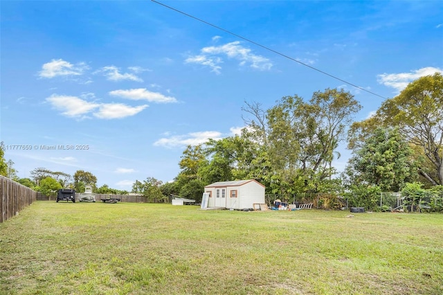 view of yard featuring a storage shed, an outbuilding, and a fenced backyard