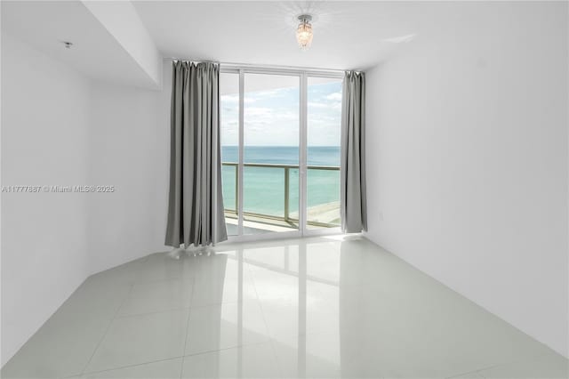 16699 Collins Ave Unit 1610, Sunny Isles Beach, FL 33160 - tiled spare room featuring floor to ceiling windows, a water view, and healthy amount of natural light