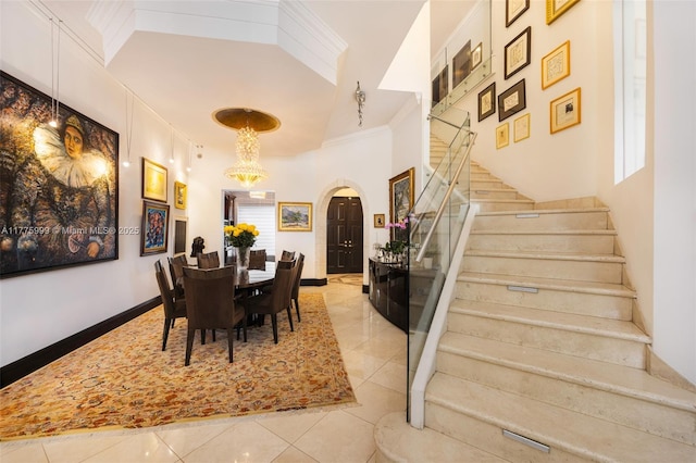 dining space with crown molding, light tile patterned flooring, a high ceiling, arched walkways, and stairs