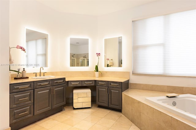 bathroom with tile patterned flooring, a garden tub, a healthy amount of sunlight, and vanity