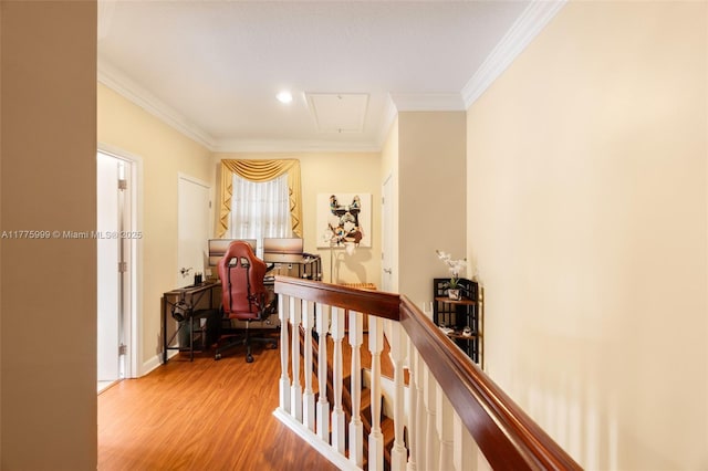 corridor with attic access, an upstairs landing, ornamental molding, and light wood finished floors