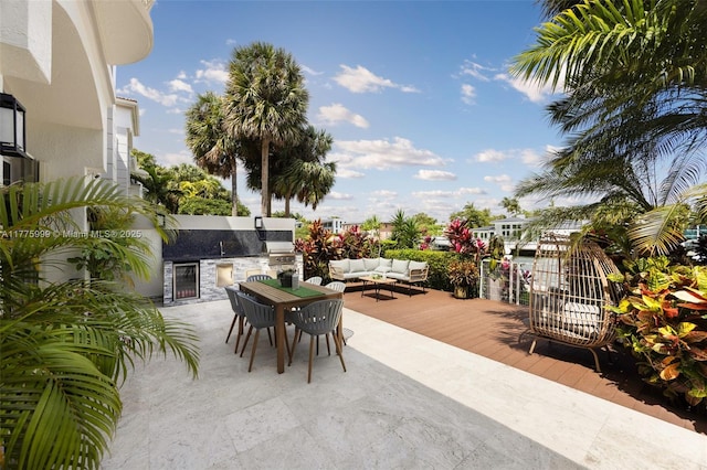 view of patio featuring outdoor dining space, exterior kitchen, an outdoor hangout area, and a deck