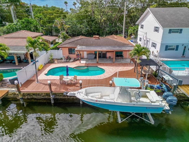 2447 SE 15th St, Pompano Beach, FL 33062 - view of pool with a pool with connected hot tub, boat lift, a dock, a fenced backyard, and a deck with water view