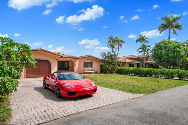 2447 SE 15th St, Pompano Beach, FL 33062 - view of front of home featuring a front yard, a tiled roof, an attached garage, stucco siding, and decorative driveway