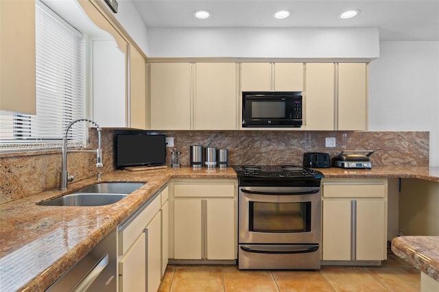2447 SE 15th St, Pompano Beach, FL 33062 - kitchen featuring black microwave, backsplash, cream cabinetry, stainless steel range with electric stovetop, and a sink