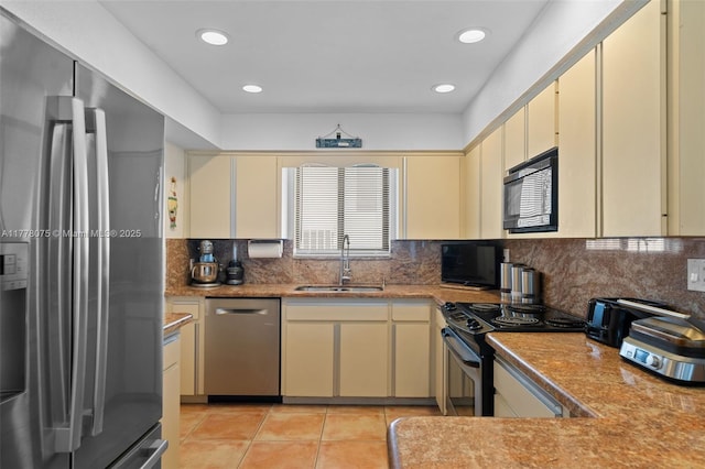 2447 SE 15th St, Pompano Beach, FL 33062 - kitchen with backsplash, a sink, cream cabinetry, and appliances with stainless steel finishes